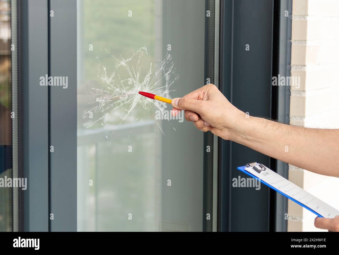 Nahaufnahme eines Mannes, der Glas in einem Haus auf einen Fensterunfall überprüft Stockfoto