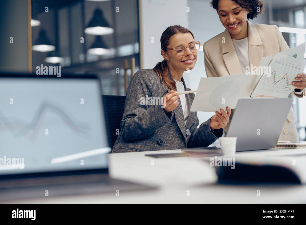 Zwei weibliche Experten für professionelle Führungskräfte diskutieren über die Zusammenarbeit mit Finanzbuchhaltungsunterlagen Stockfoto