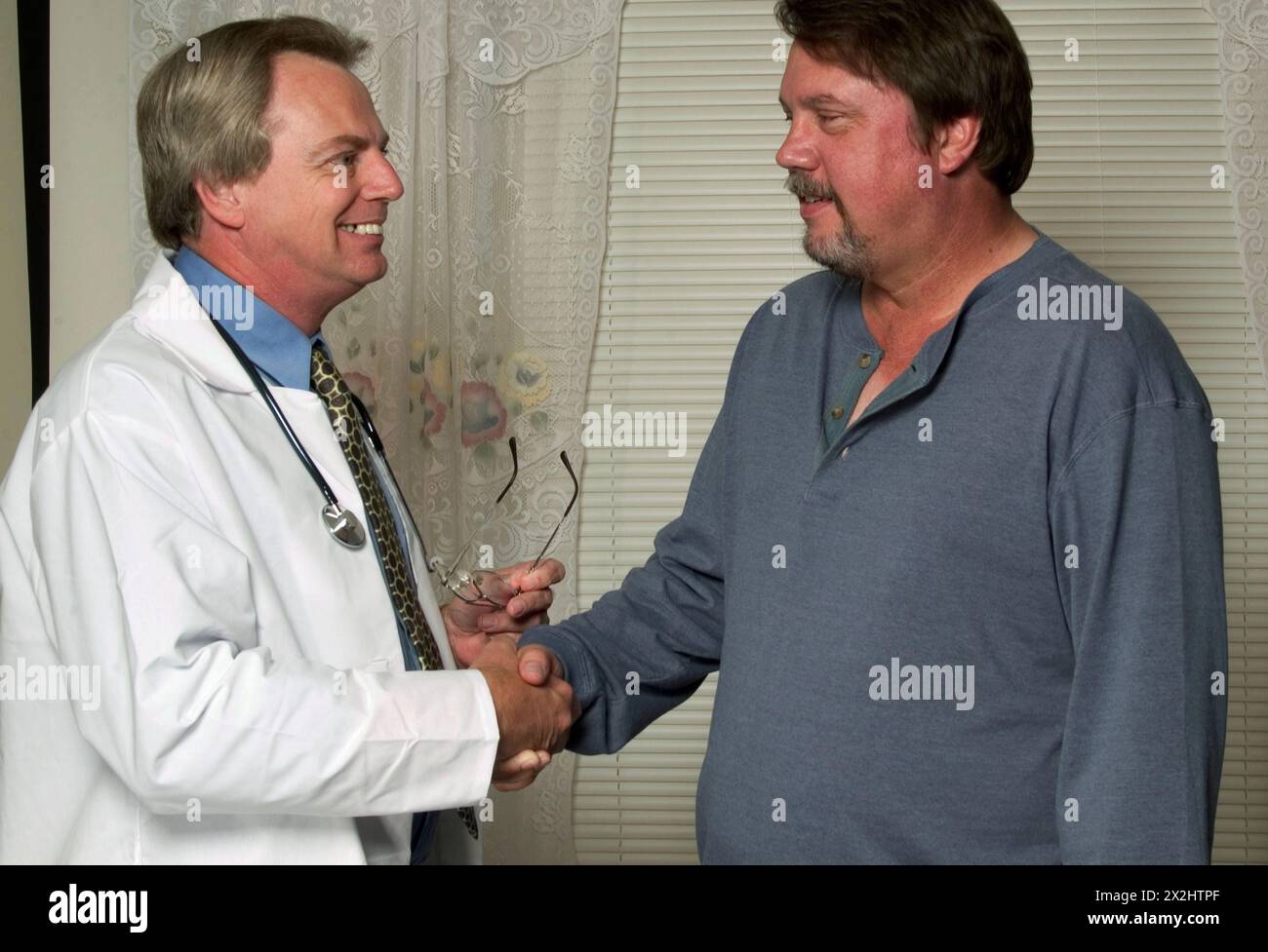 Männlicher kaukasischer Arzt schüttelt Hände mit männlichem Patienten in der Arztpraxis, USA. Stockfoto