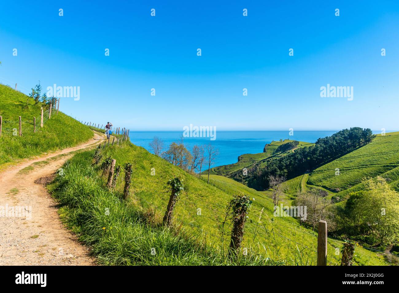 Pfad und eine wunderschöne Landschaft mit einem Mann auf dem Weg zum Flysch von Zumaia, Gipuzkoa. Baskenland Stockfoto