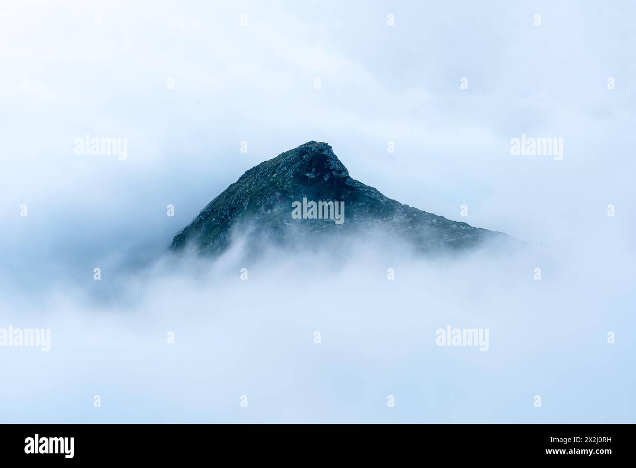 Isolierter Berggipfel, umgeben von einem Wolkenmeer Stockfoto