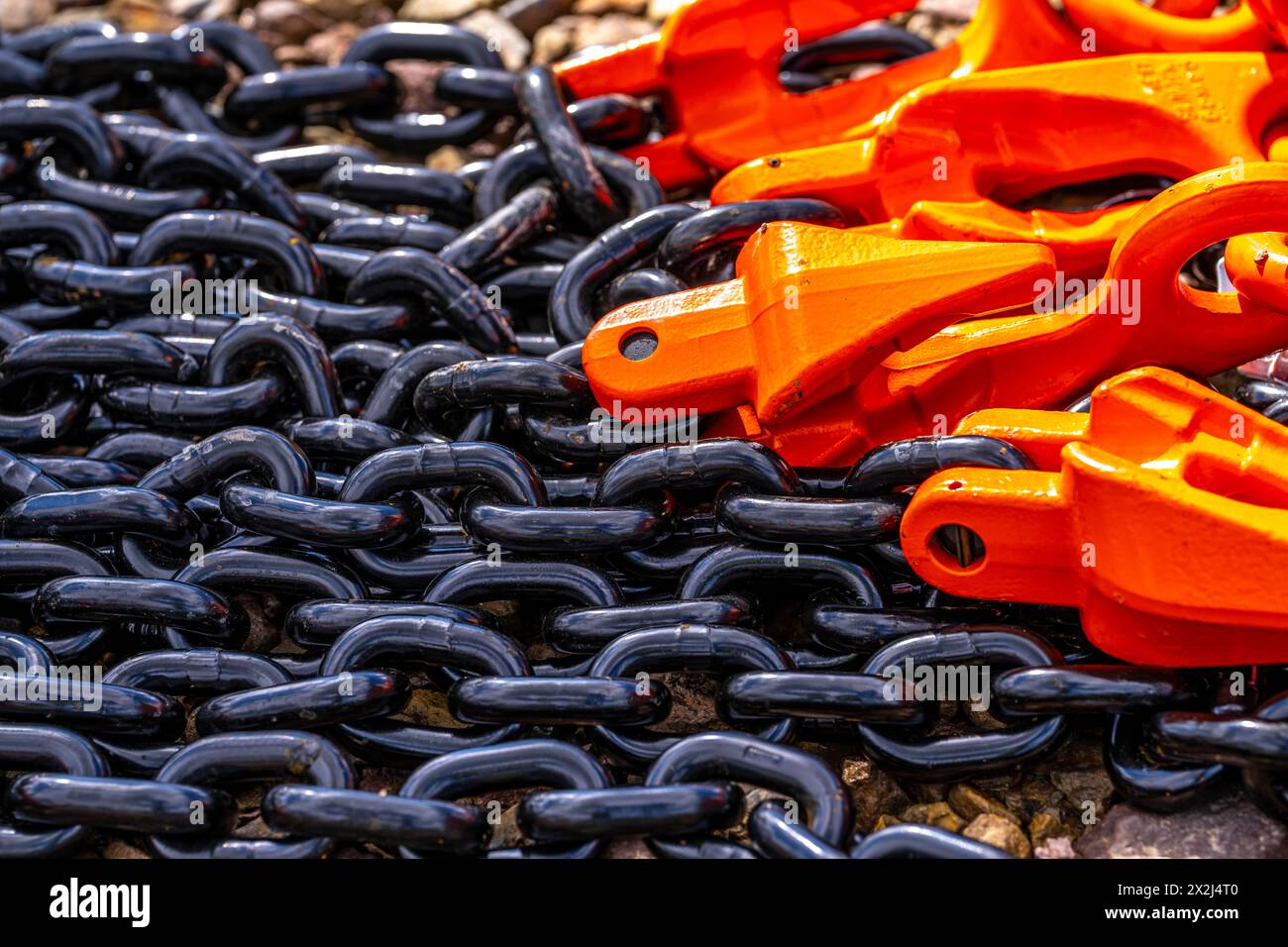 Schwere, dicke Ketten aus Stahl, schwarze Kettenglieder, orange lackierte Haken, Deutschland, Stockfoto
