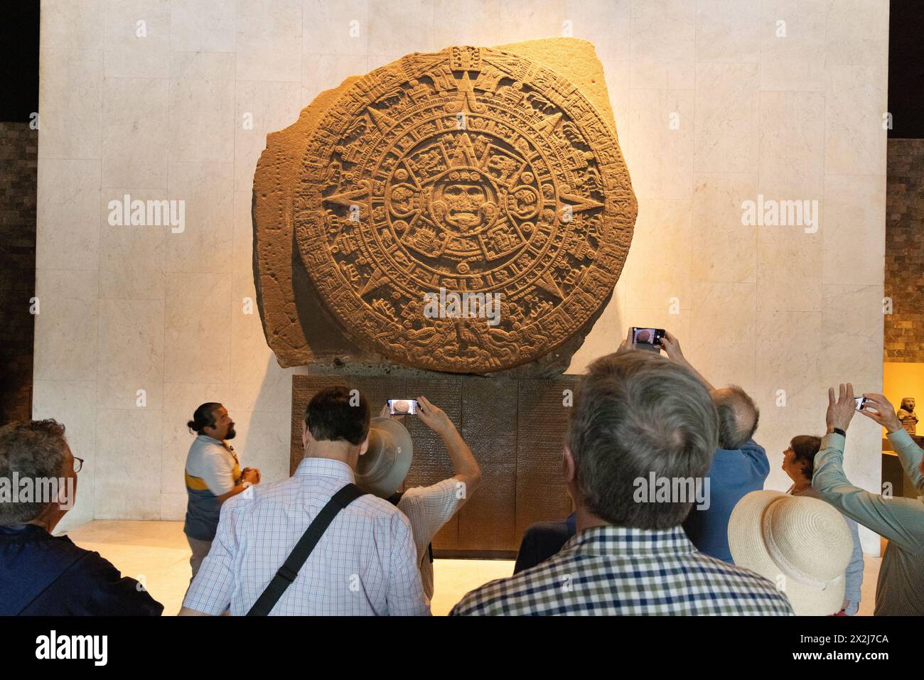 Touristen, die sich den Aztekischen Sonnenstein oder den Aztekenkalender ansehen; Anfang der 1500er Jahre, Mexica Aztekische Skulptur, Nationalmuseum für Anthropologie, Mexiko-Stadt, Mexiko Stockfoto