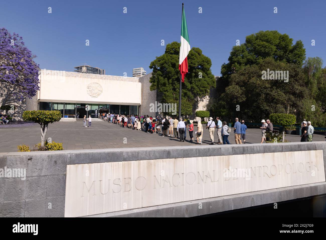 Nationalmuseum für Anthropologie, Mexiko-Stadt; - Außenansicht des Eingangs, wo die Touristenmassen in der Warteschlange stehen. Mexiko. Stockfoto