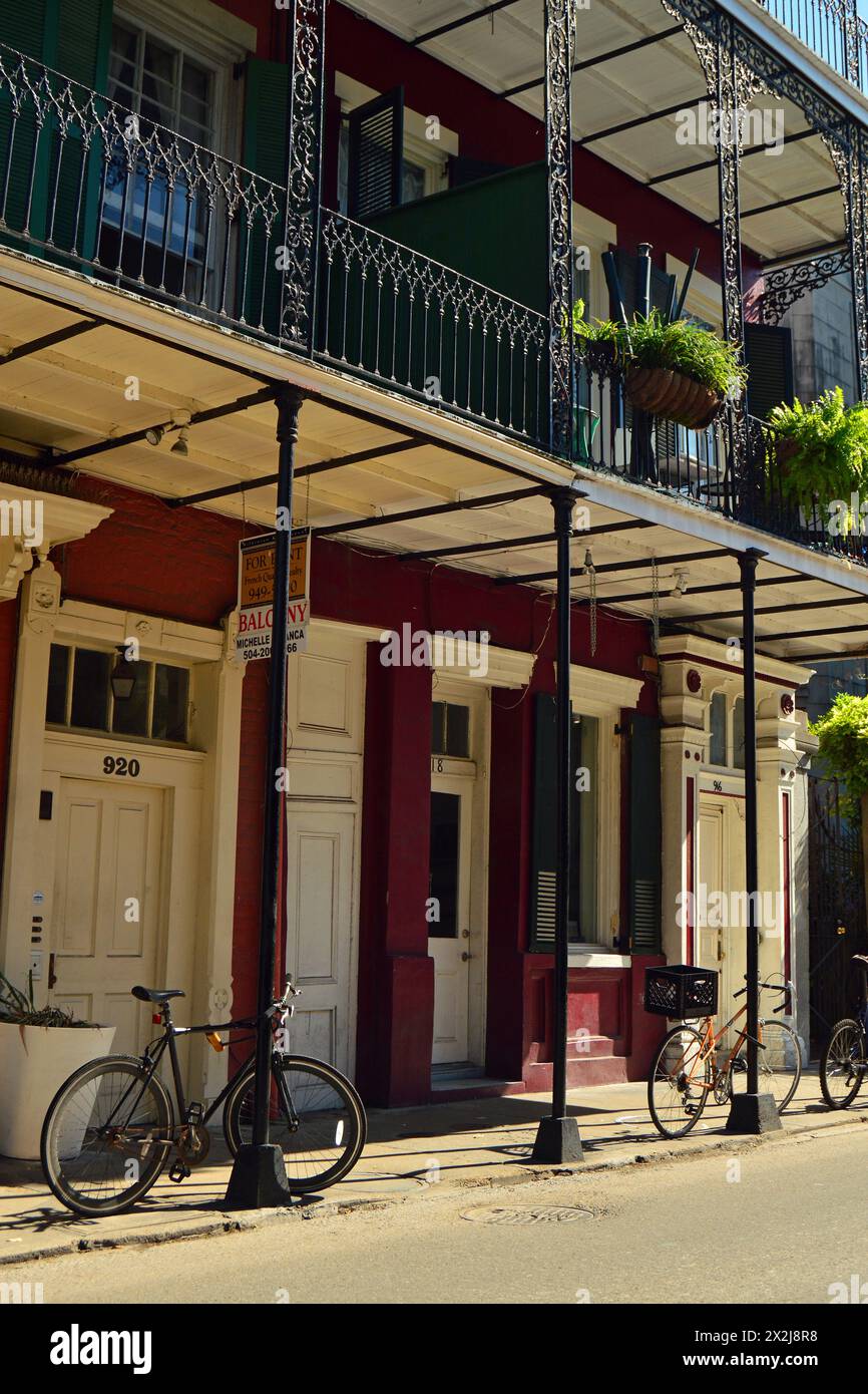 Die Fahrräder sind an den Stangen der historischen Gebäude im New Orleans French Quarter befestigt Stockfoto