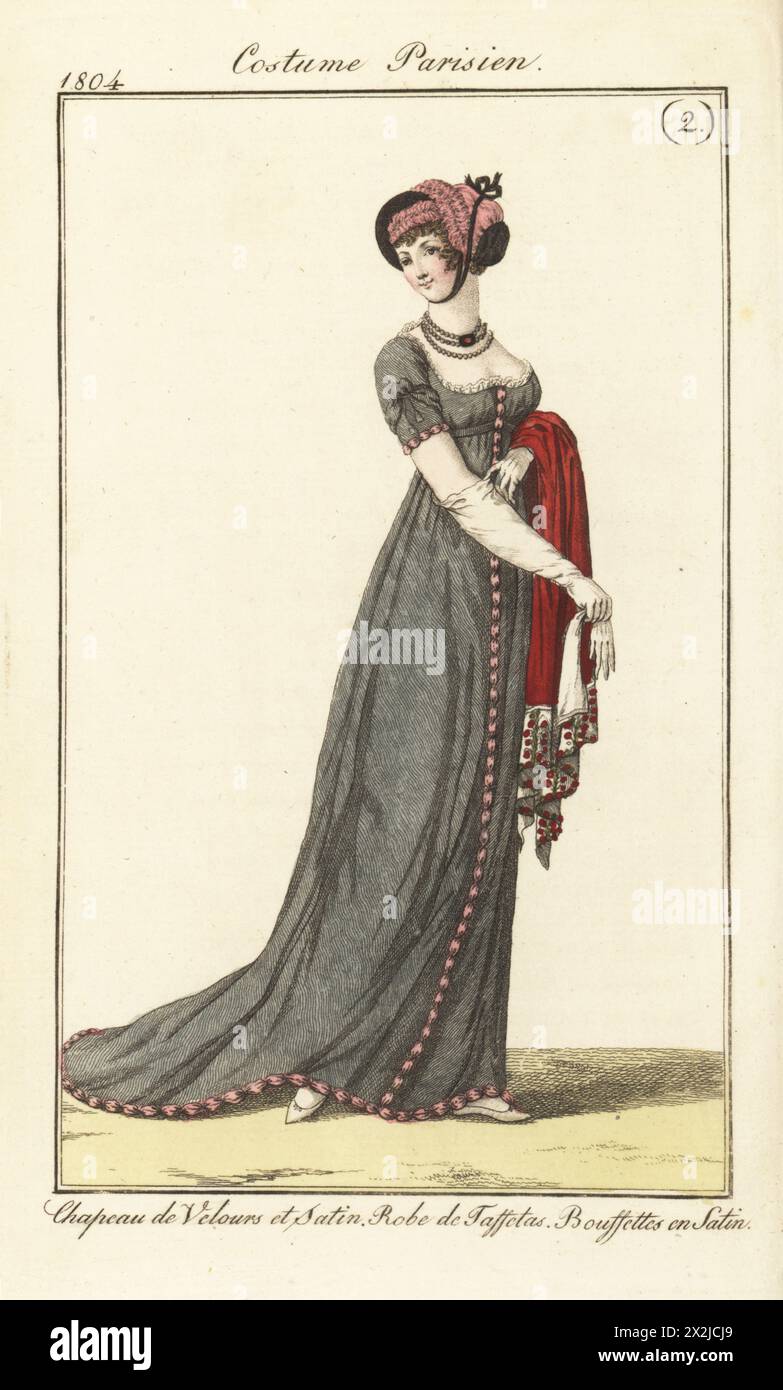 Frau in rosa Satin und schwarzem Samtmütze unter dem Kinn gebunden, tief geschnittenes Taffeta-Gewand mit rosa Satin-Bouffetten, die einen scharlachroten Schal halten. Chapeau de Velours et satin. Robe de Taffetas. Bouffettes en Satin. Pl. 519 in der Pariser Ausgabe. Handkolorierter Kupferstich aus Pierre de la Messengere’s Journal des Dames et des Modes, Francfort sur le mein (Frankfurt) 1804. Nach Illustrationen von Carle Vernet, Jean-Francois Bosio, Dominique Bosio und Philibert Louis Debucourt. Stockfoto