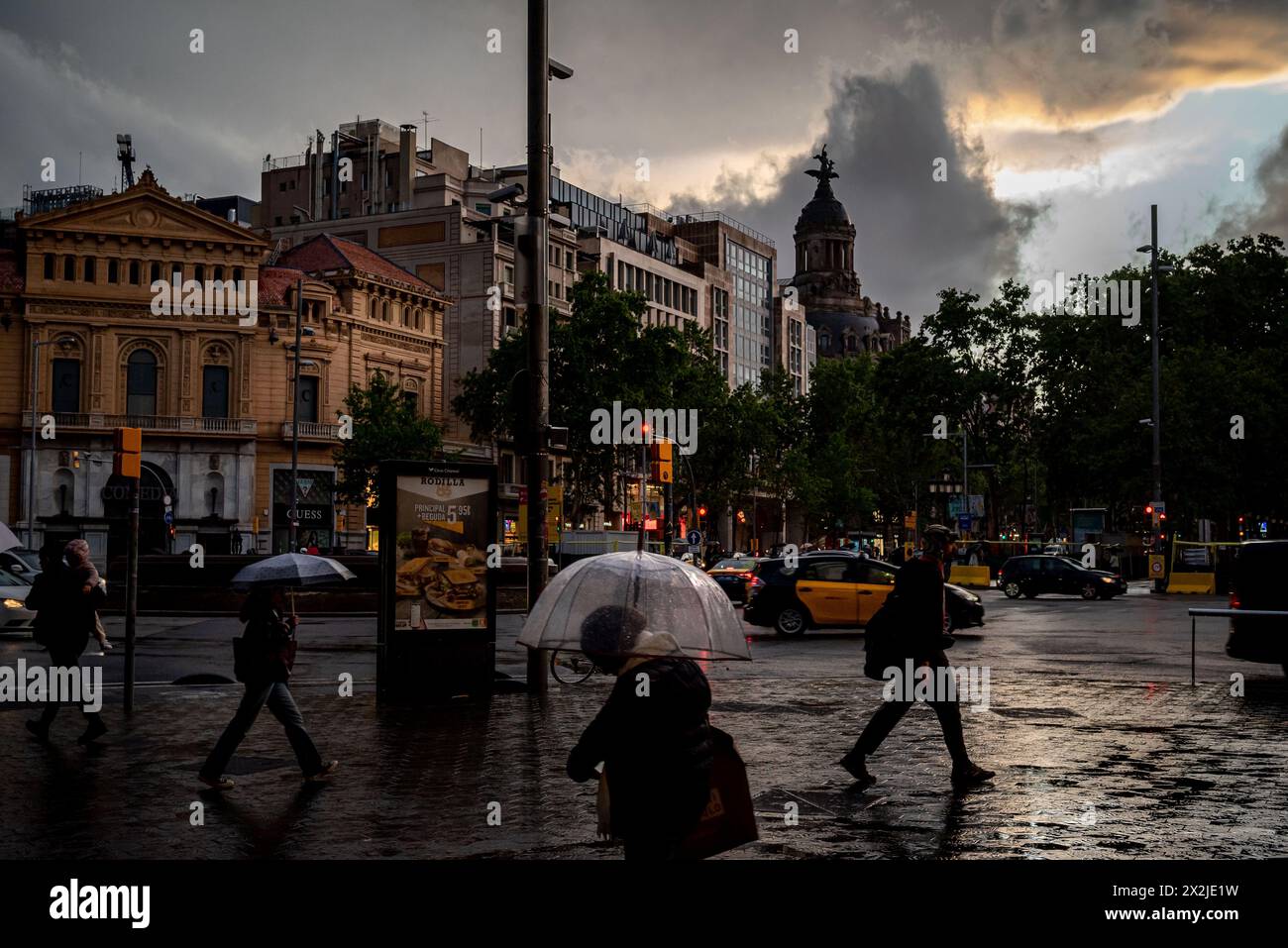 Fußgänger gehen nach einem Regenregen an der Passeig de Gracia Straße in Barcelona vorbei. Stockfoto