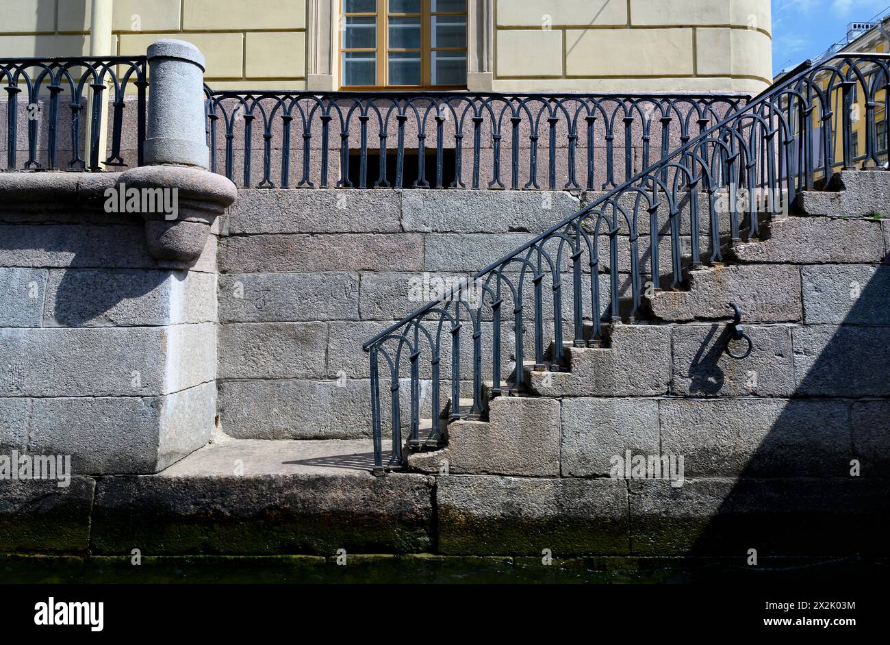 Granittreppe mit durchbrochenem Geländer aus dem 18. Jahrhundert, die zum Fontanka River in St. Petersburg Stockfoto