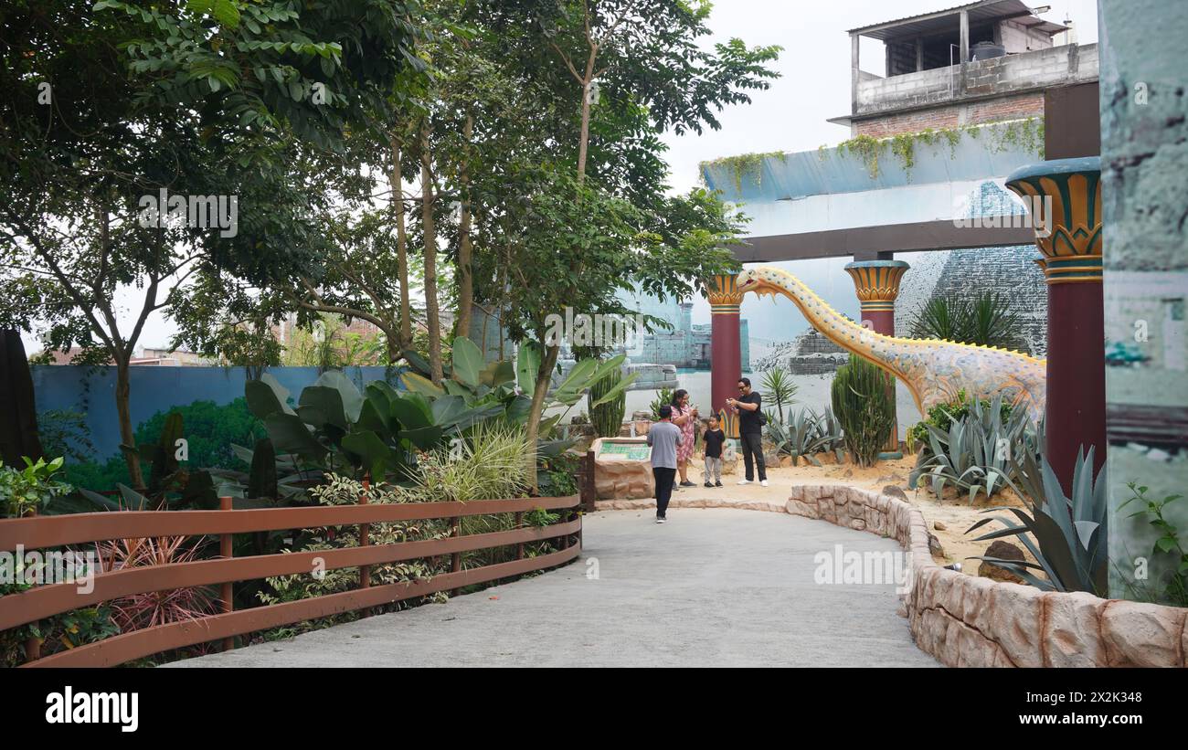 Dino Park im Jatim Park 3 mit Dinosaurierstatuen und einigen Besuchern, die tagsüber Fotos machen Stockfoto