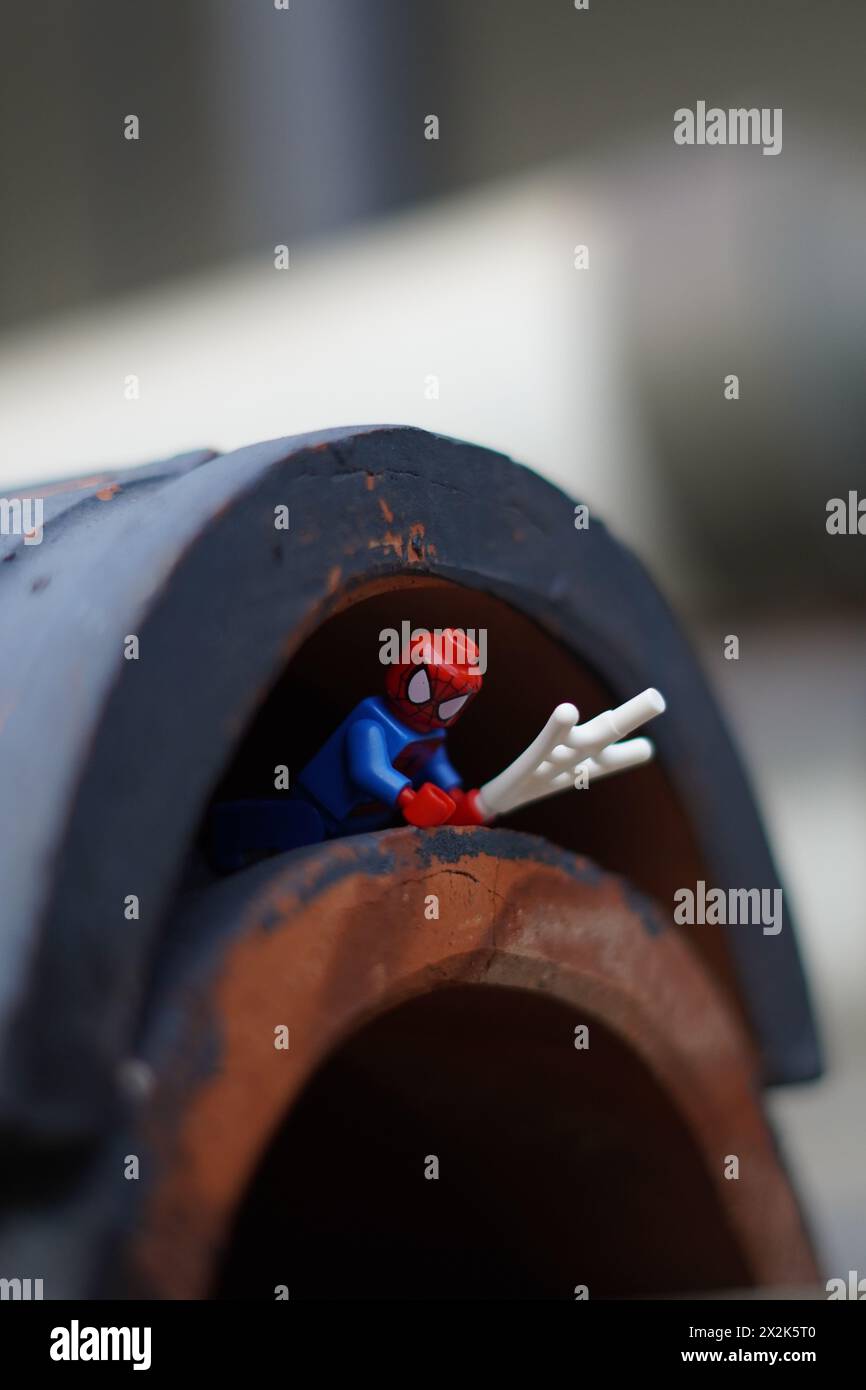 Die LEGO Minifigur spiderman krabbelt unter einem Tunnel mit verschwommenem Hintergrund Stockfoto