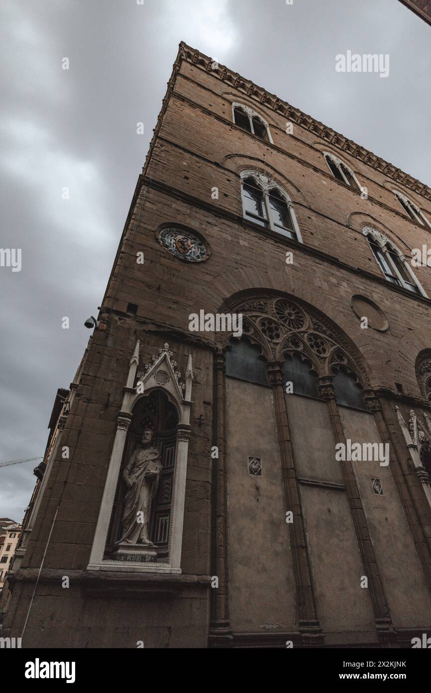 Straßenszene im Zentrum von Florenz in der Toskana, Italien, mit klassischer Architektur von der Straße aus. An einem bewölkten Tag mit grauem, stimmungsvollem Himmel. Stockfoto