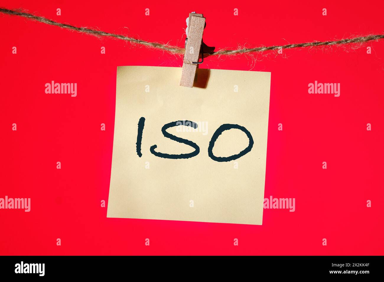 Das Konzept der ISO-Qualitätskontrollzertifizierung. Abkürzung ISO es wird auf einem gelben Aufkleber auf rotem Hintergrund geschrieben Stockfoto