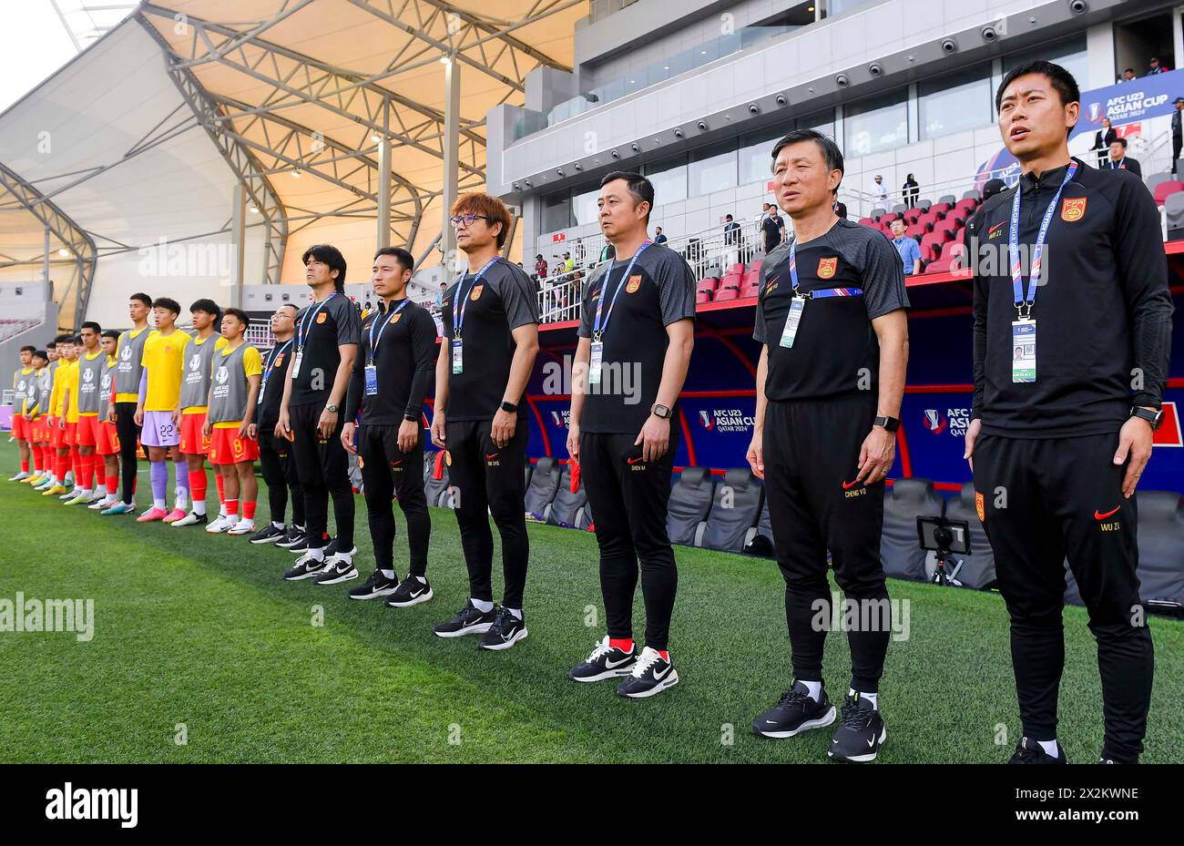 (240423) -- DOHA, 23. April 2024 (Xinhua) -- Substitute und Trainer Chinas treten für Nationalhymnen an, bevor sie am 22. April 2024 das Gruppenspiel zwischen China und den Vereinigten Arabischen Emiraten des AFC U23 Asian Cup Katar 2024 in Doha, Katar, ausgetragen haben. (Foto: Nikku/Xinhua) Stockfoto