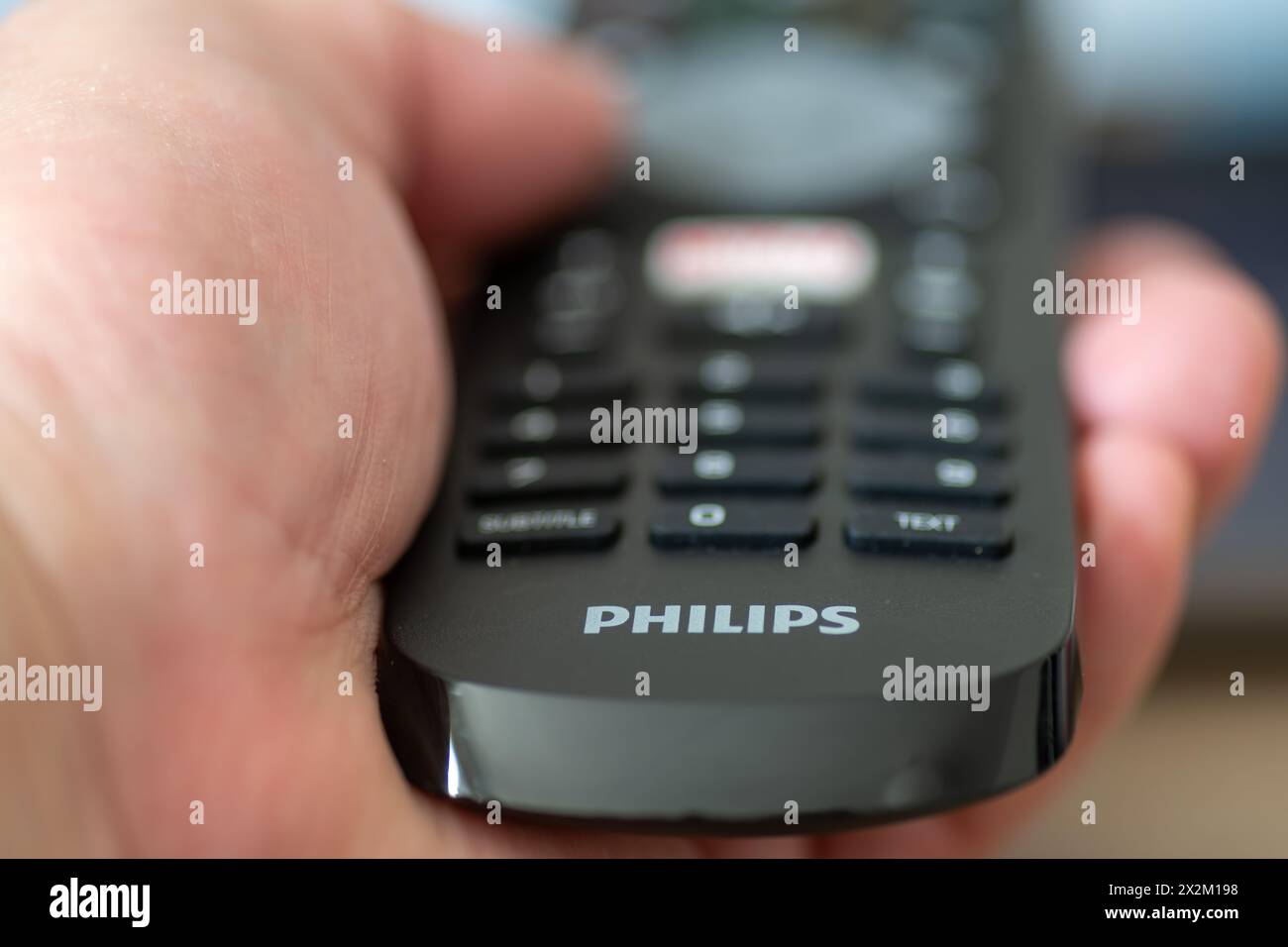 London. UK- 04.17.2024. Eine Hand, die eine Fernbedienung des niederländischen multinationalen Konzerns Philips hält. Stockfoto