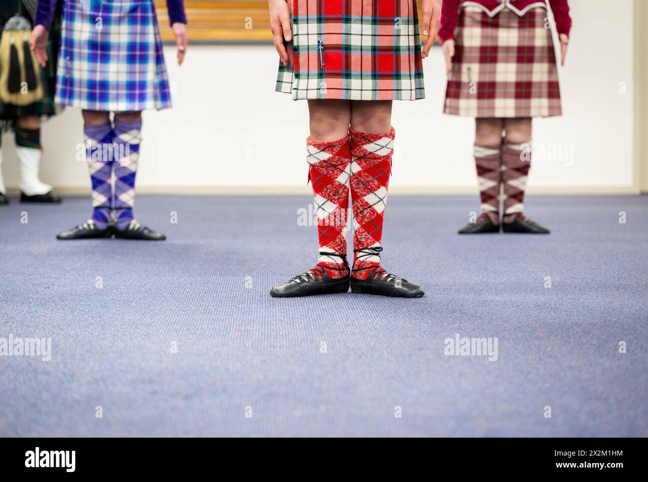 Highland-Tänzer mit wunderschönen Kostümen im Tanzclub. Stockfoto