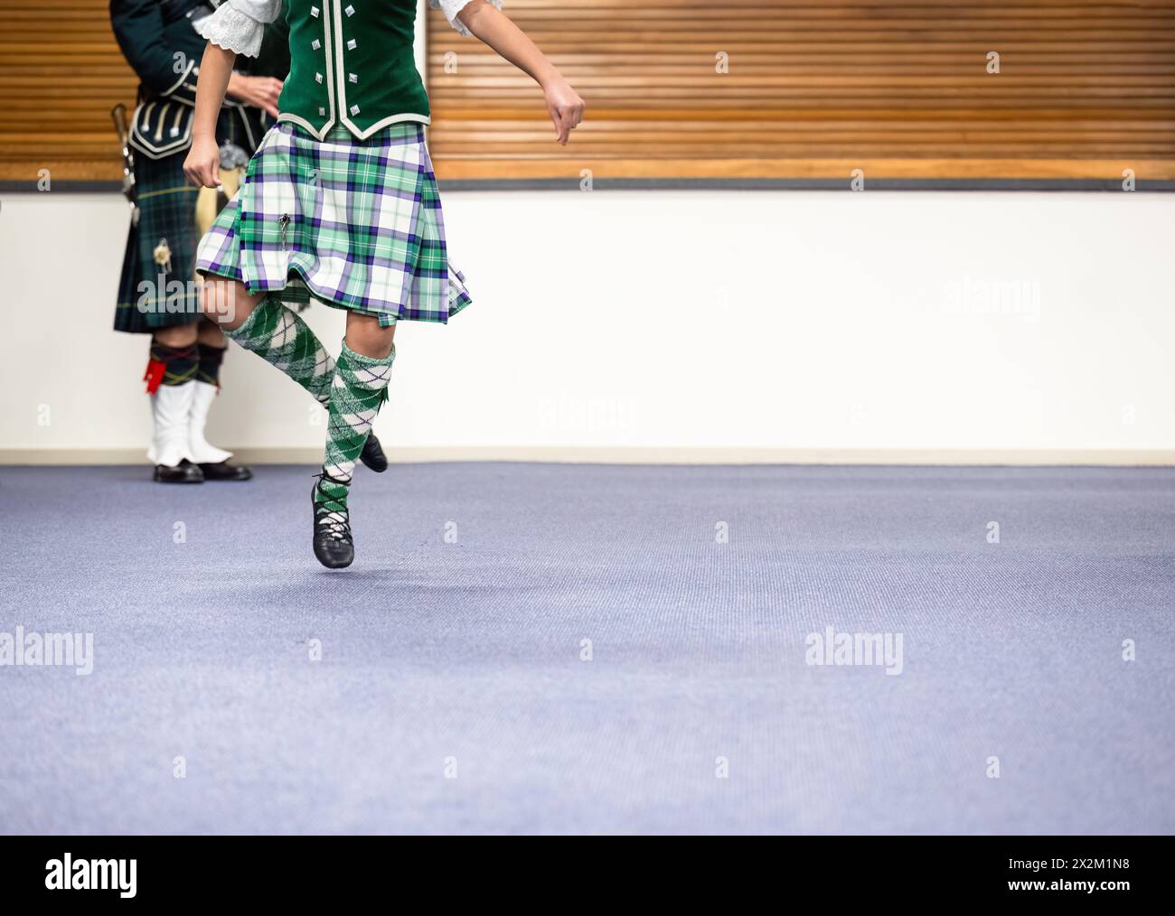 Highland-Tänzer und Piper treten in einem Tanzclub auf. Stockfoto