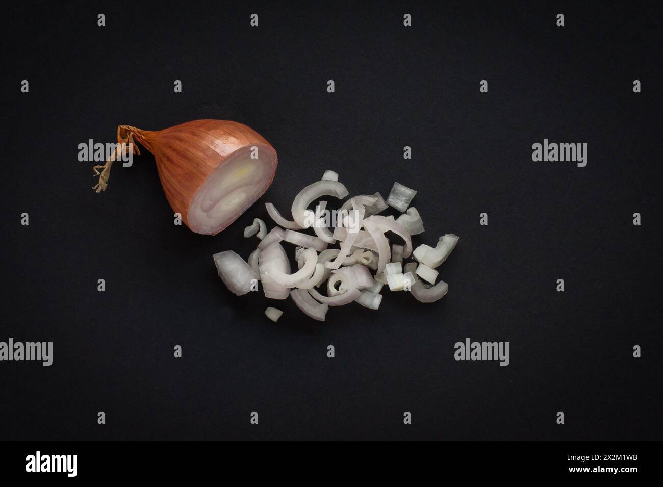 Halbe Schalotte und gehackte Schalotten auf schwarzem Hintergrund Stockfoto