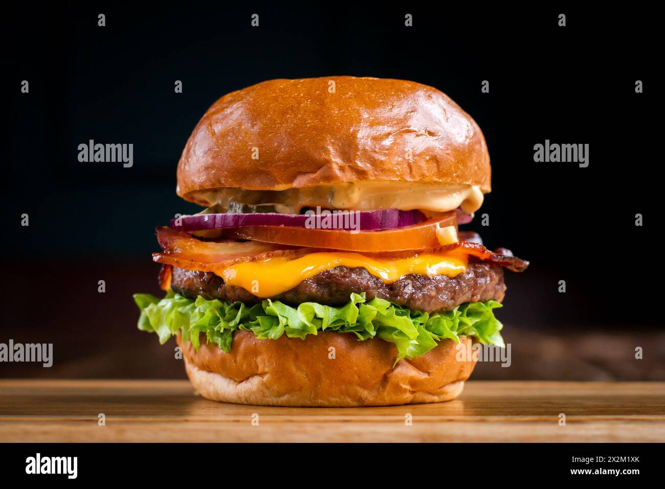 Cheeseburger mit Speck auf einem Holzbrett in einem Restaurant Stockfoto
