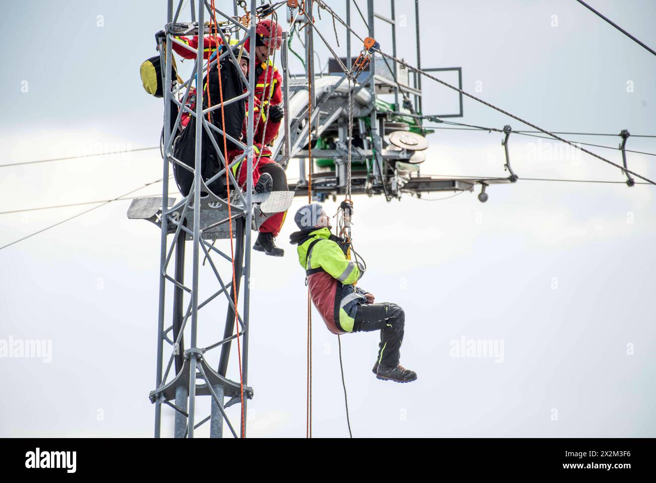 Eine Person wird von Höhenretter der Berufsfeuerwehr Rostock von einem Mast der Wakeboardanlage in Rostock Schmarl gerettet. Vor der Kulisse des Überseehafens an der Warnow wird die Berufsfeuerwehr Rostock erstmals eine Übung in der Wassersportanlage durchführen. Das Szenario umfasst einen medizinischen Notfall bei einem Servicetechniker bei Wartungsarbeiten an einem der 13 Meter hohen Motormasten der Wakeboardanlage auf der Rostocker Warnow. Die Rettung des Mannes erfordert den Einsatz der Höhenretter, wobei die Herausforderung besteht, dass der Rettungspunkt direkt über dem Wasser liegt. Stockfoto