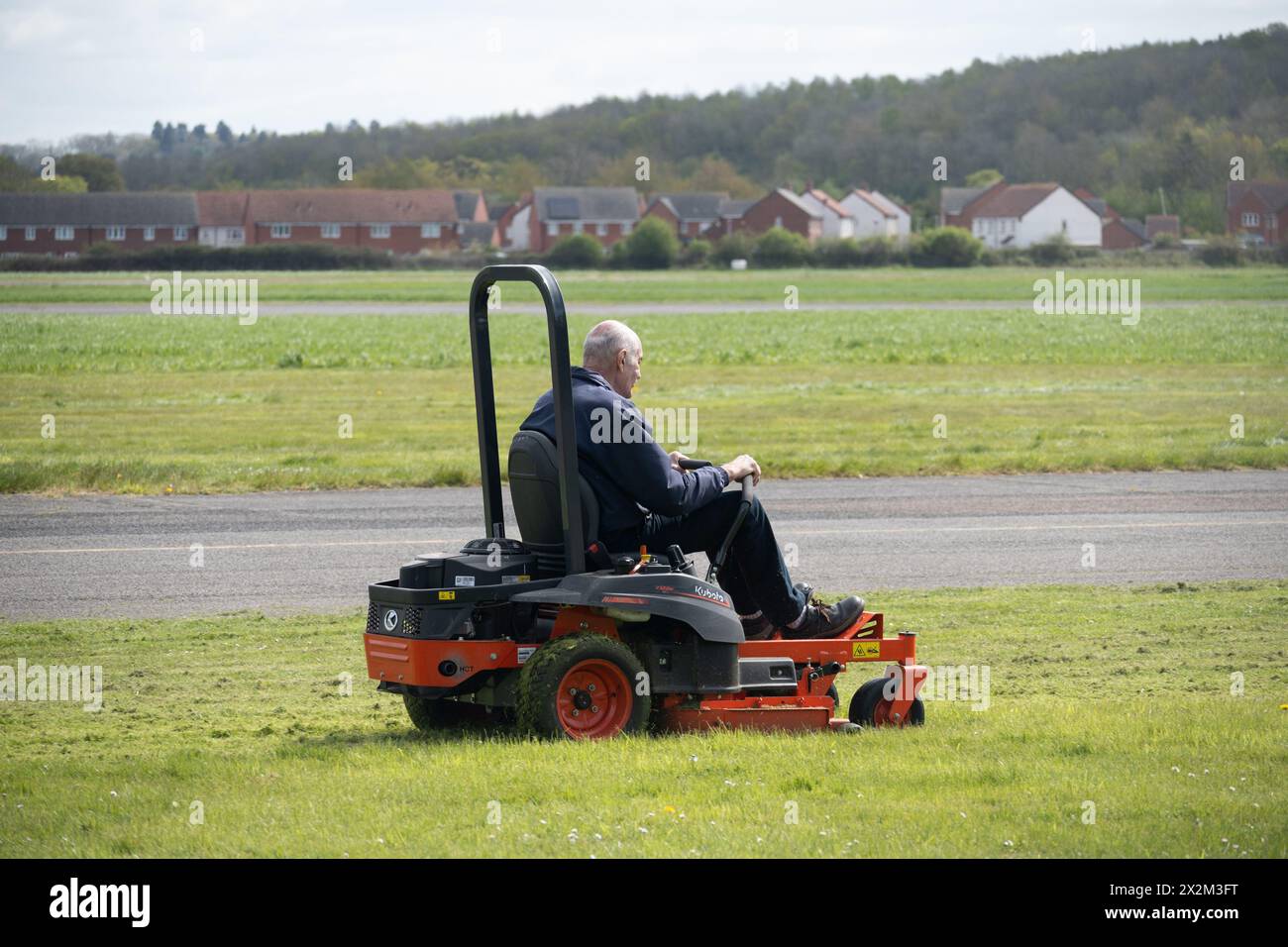 Mann mit einem Kubota Aufsitzmäher am Wellesbourne Airfield, Warwickshire, Großbritannien Stockfoto