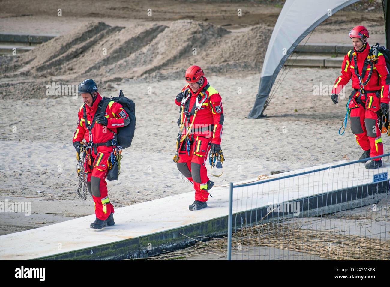 Eine Person wird von Höhenretter der Berufsfeuerwehr Rostock von einem Mast der Wakeboardanlage in Rostock Schmarl gerettet. Vor der Kulisse des Überseehafens an der Warnow wird die Berufsfeuerwehr Rostock erstmals eine Übung in der Wassersportanlage durchführen. Das Szenario umfasst einen medizinischen Notfall bei einem Servicetechniker bei Wartungsarbeiten an einem der 13 Meter hohen Motormasten der Wakeboardanlage auf der Rostocker Warnow. Die Rettung des Mannes erfordert den Einsatz der Höhenretter, wobei die Herausforderung besteht, dass der Rettungspunkt direkt über dem Wasser liegt. Stockfoto