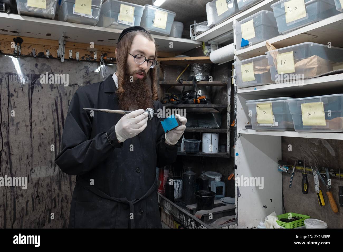 Ein orthodoxer chassidischer Mann repariert und restauriert Tefillin in einem kleinen Büro. Im Rockland County, New York. Stockfoto