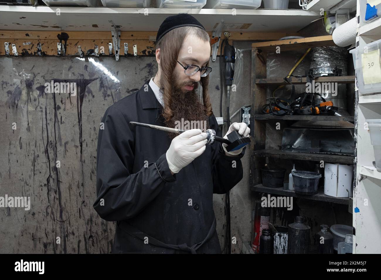 Ein orthodoxer chassidischer Mann repariert und restauriert Tefillin in einem kleinen Büro. Im Rockland County, New York. Stockfoto