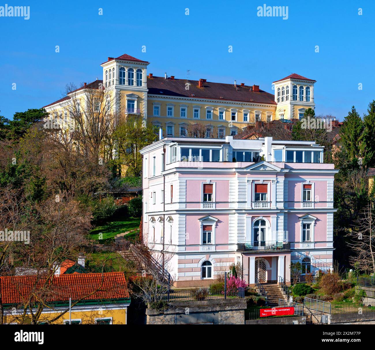 Historische Villa und das Gebäude des ehemaligen Luxushotels Bellevue bei Sonnenschein in Bath Voeslau, Österreich Stockfoto