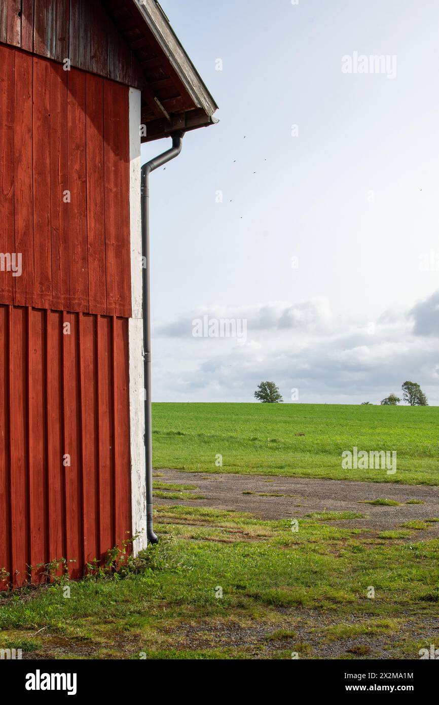 Teil der roten Holzscheune mit Ackerfeld im Hintergrund Stockfoto