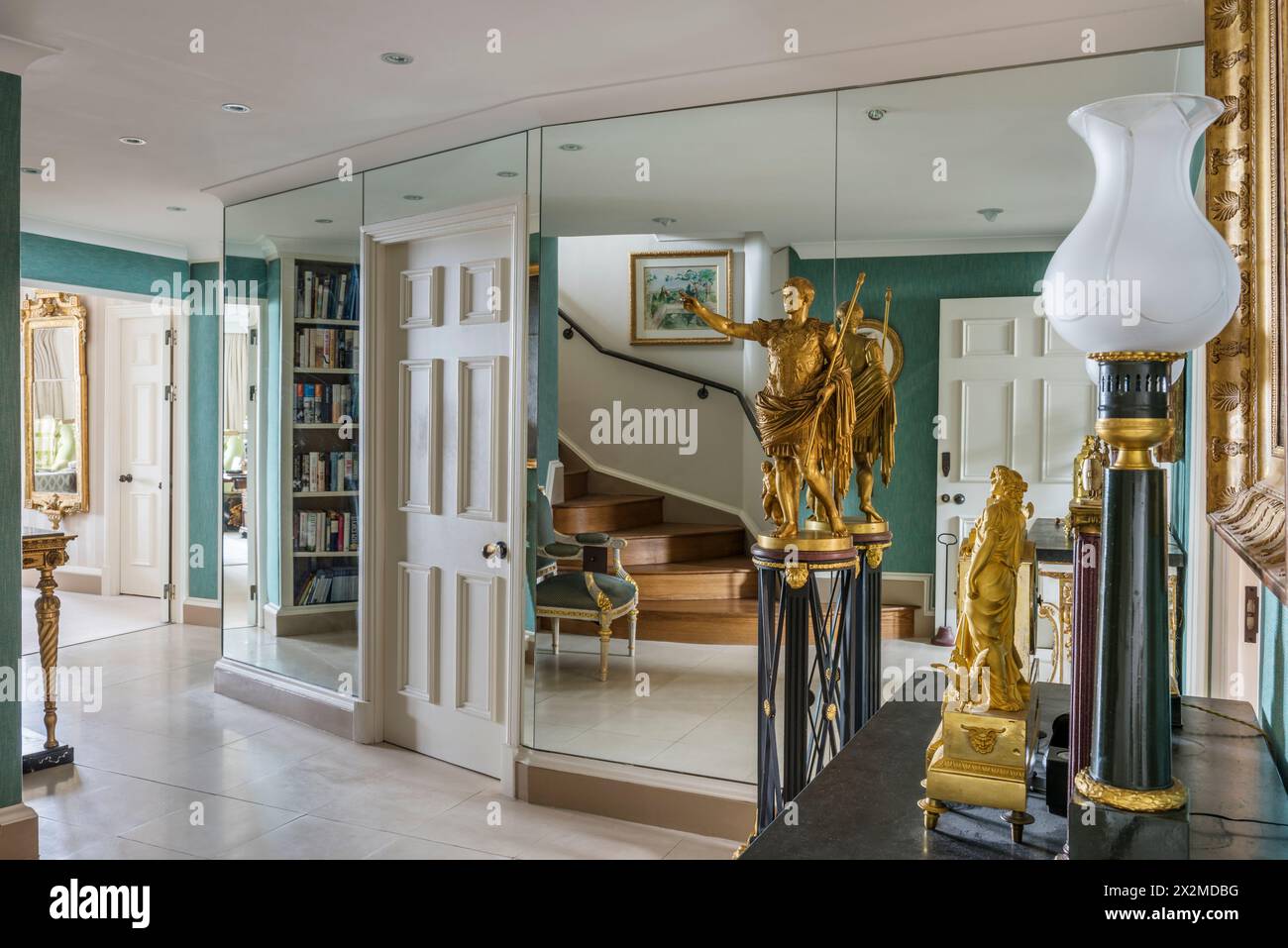 Goldene Statue und Spiegelwand in Chelsea Apartment, London, Großbritannien Stockfoto