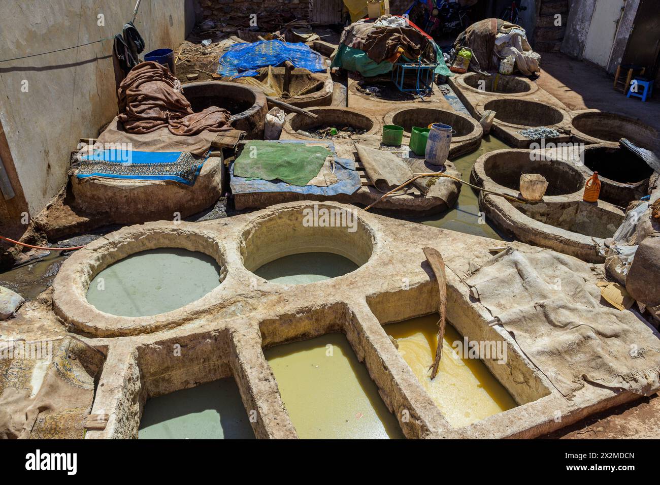 Alte, mit lebhaften Farbstoffen gefüllte Gerbbehälter in einer traditionellen marokkanischen Gerberei in Fès, die den historischen Lederfärbeprozess demonstrieren. Stockfoto