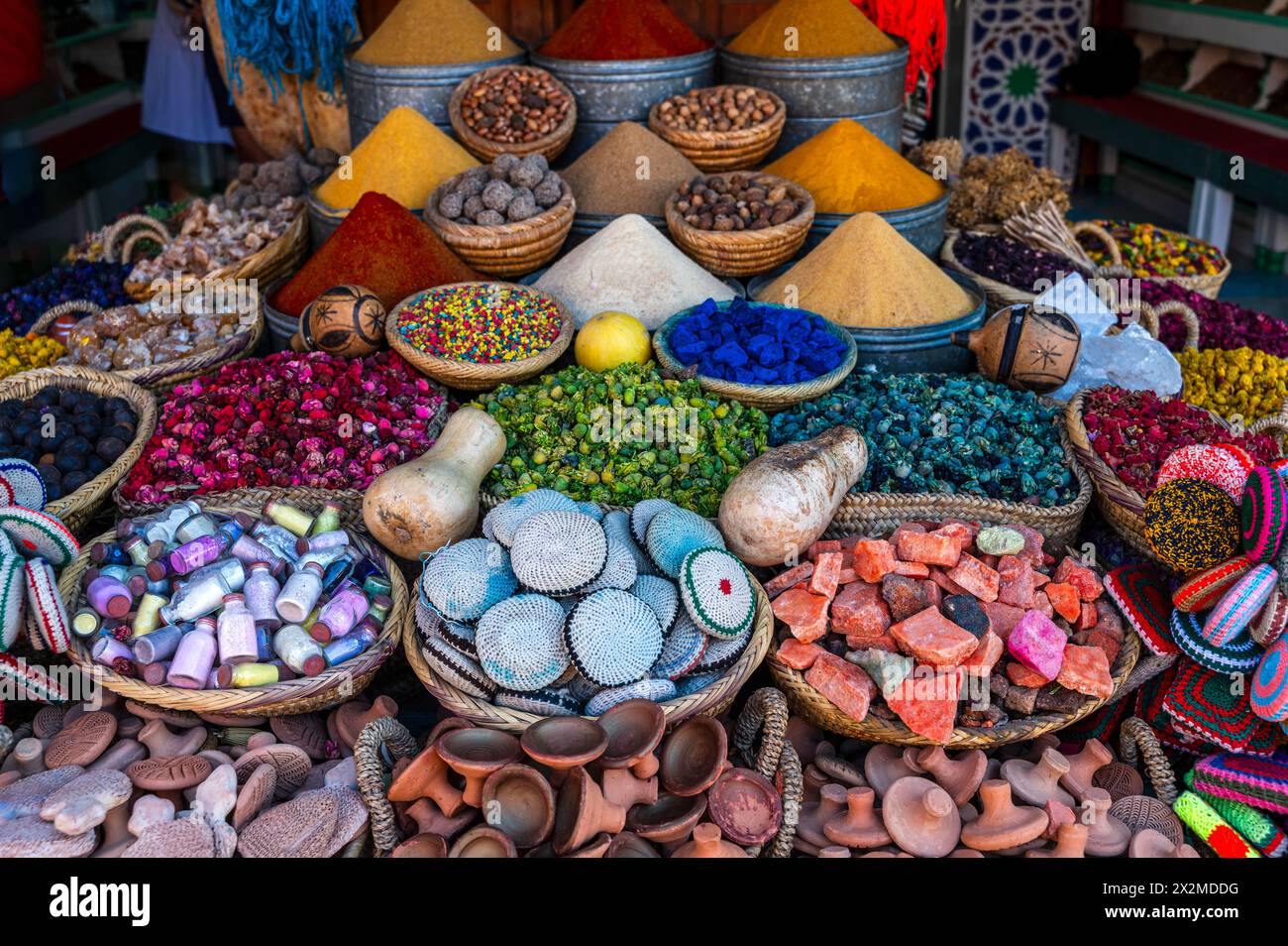 Farbenfrohe Auswahl an Gewürzen, getrockneten Früchten und traditionellem marokkanischem Kunsthandwerk, das auf einem lokalen Markt in Marokko präsentiert wird, präsentiert wird Stockfoto