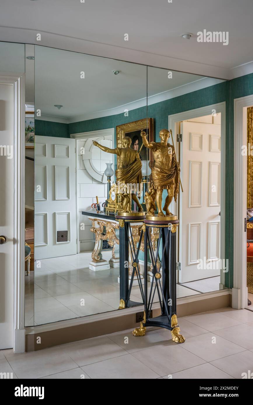 Goldene Statue und Spiegelwand in Chelsea Apartment, London, Großbritannien Stockfoto