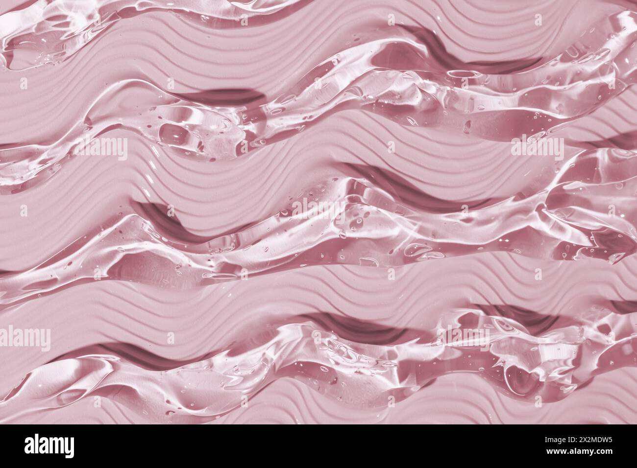 Dieses Bild zeigt eine Nahaufnahme glatter, welliger pinkfarbener Geltexturen, die eine beruhigende und fließende Ästhetik verleihen Stockfoto