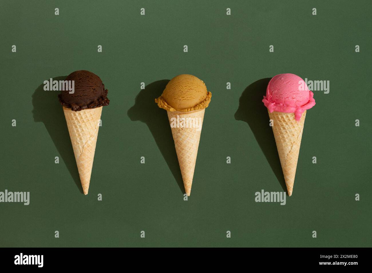 Buntes Sortiment an Eiskegeln auf grünem Hintergrund Stockfoto