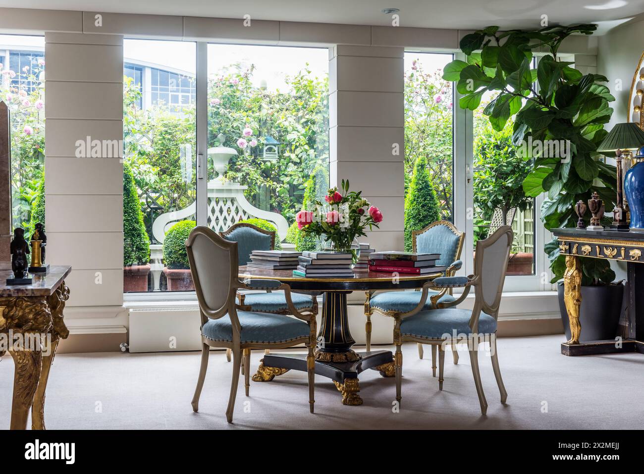 Antike Stühle auf dem Tisch mit Büchern im Fenster des Apartments Chelsea, London, Großbritannien Stockfoto