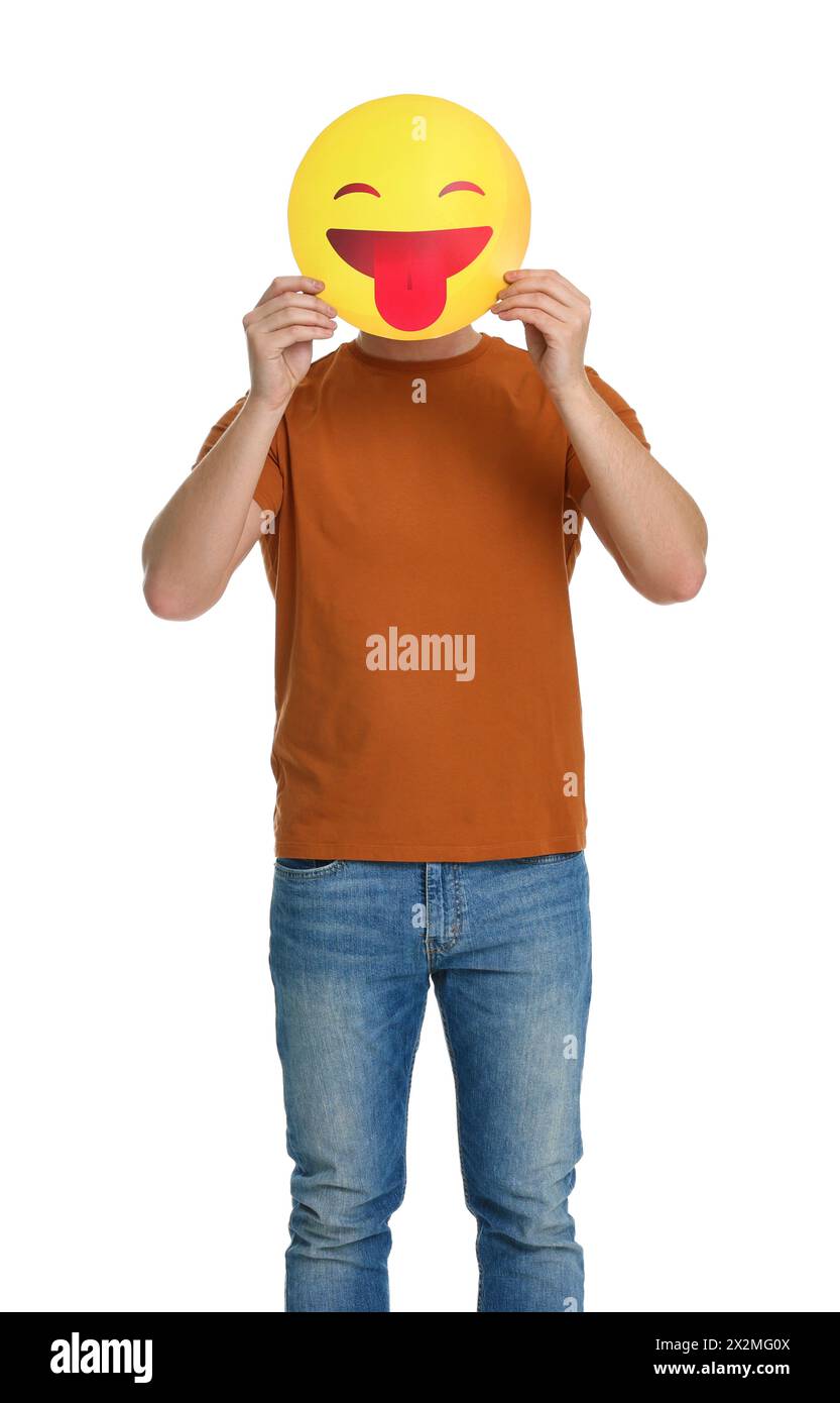 Mann, der das Gesicht mit Emoticon bedeckt, der die Zunge auf weißem Hintergrund hinausragt Stockfoto