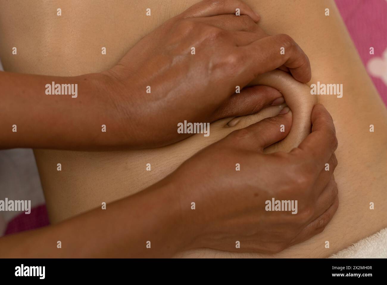 Latina-Frau erhält eine Körperschlankheitsmassage mit spezifischen Druckpunkten Stockfoto