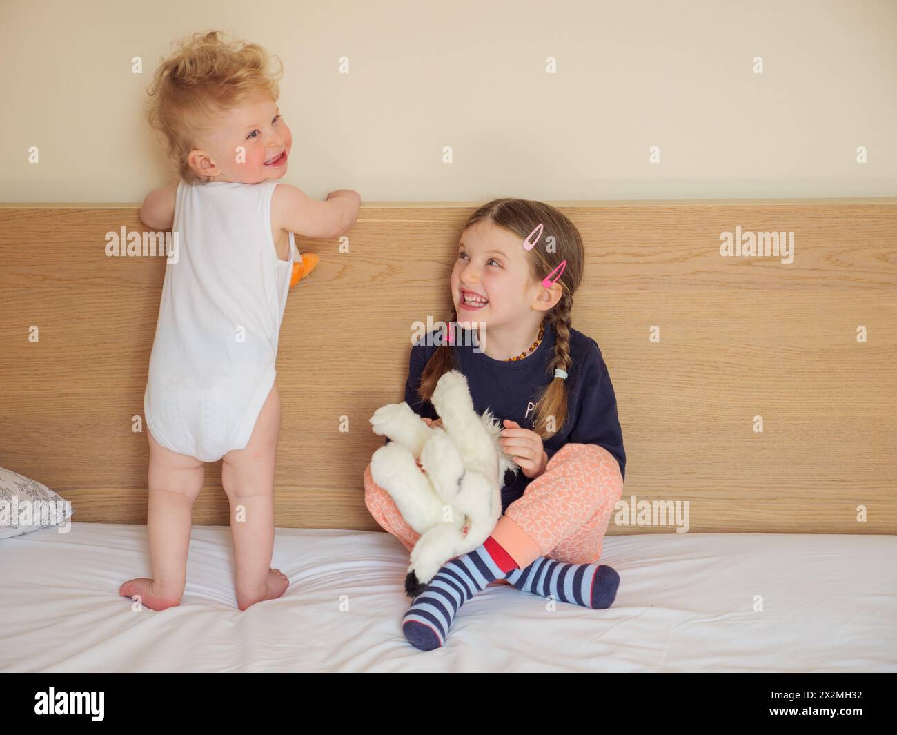 Der kleine Bruder und seine großen Geschwister haben Spaß zusammen als kleine Kinder, die ihre Kindheit zu Hause genießen Stockfoto
