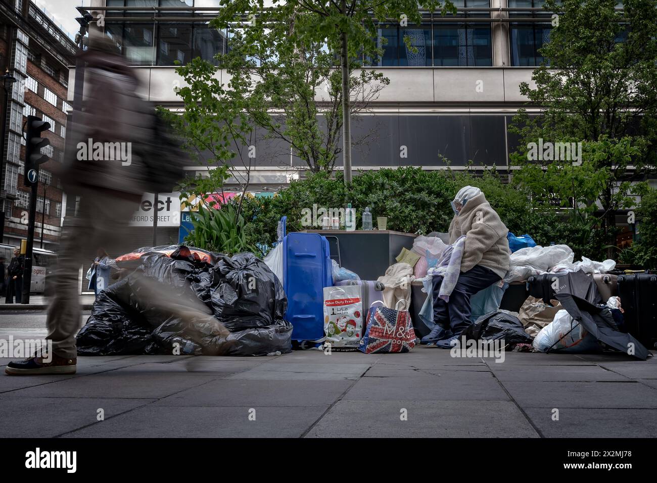 Eine Obdachlose und ihre Habseligkeiten, die tagsüber in der Oxford Street in London gesehen wurden. Stockfoto