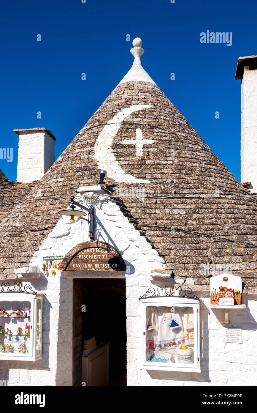 Weiß getünchte Symbole auf dem renovierten Steindach von A Trullo, Alberobello, Italien Stockfoto