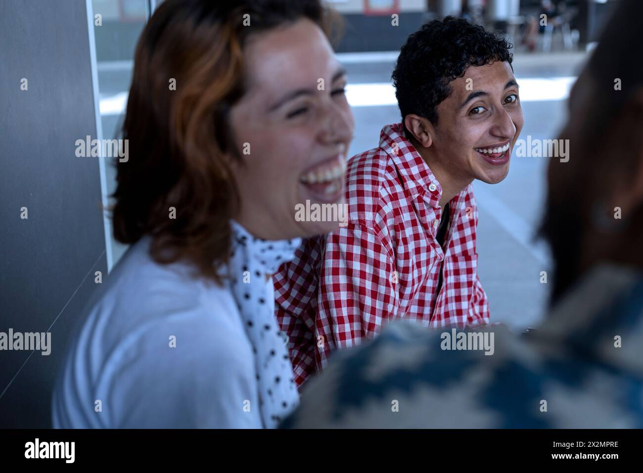 Drei lateinamerikanische Freunde im Urlaub unterhielten sich amüsant und sehr glücklich, ihren Sommerurlaub zu genießen. Urlaubskonzept und echte Leute Stockfoto