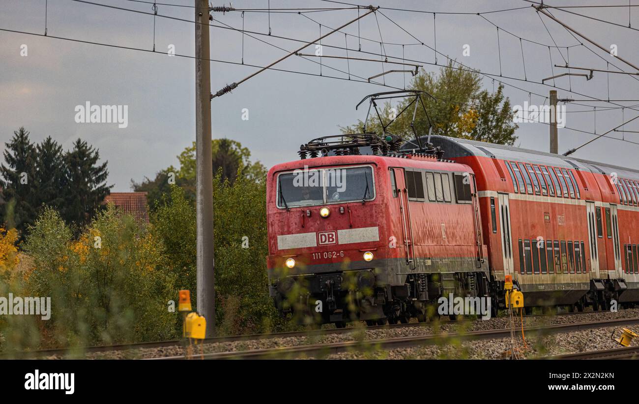 Ein Personenzug mit einer Lokomotive der Baureihe 111 der Deutschen Bahn ist mit Doppelstockwagen auf der Bahnstrecke zwischen Nürnberg und München un Stockfoto