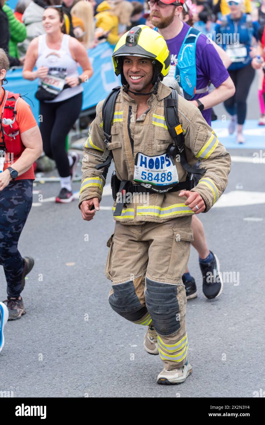 Matt Hooper nahm am TCS London Marathon 2024 Teil und fuhr durch Tower Hill, London, Großbritannien, in Feuerwehruniform Stockfoto