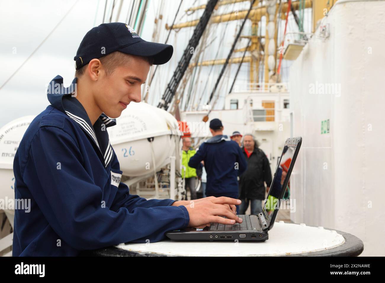 STAVANGER - 28. JULI: Seemann des russischen Schiffes Kruzenshtern arbeitet mit Laptop bei Stavanger Tall Races am 28. Juli 2011 in Stavanger, Norwegen. Viele Schiffe Stockfoto