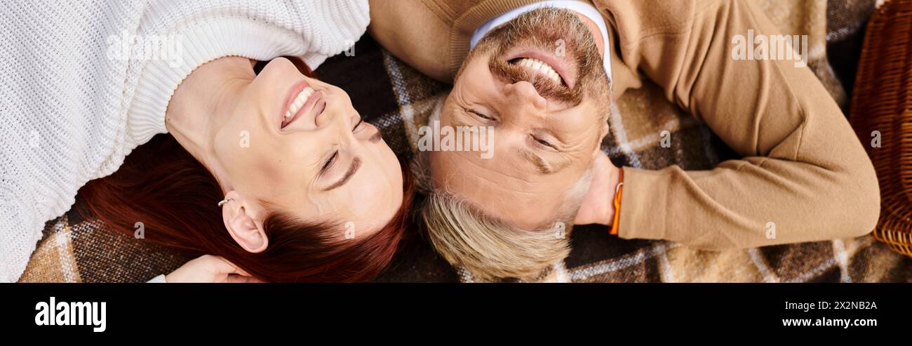 Ein Mann und eine Frau liegen friedlich auf einer Decke im Park. Stockfoto