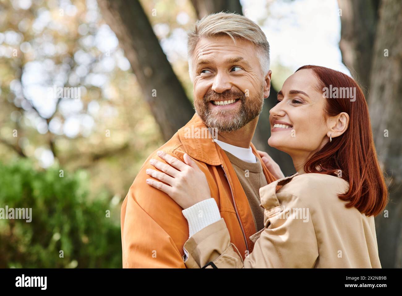 Ein Mann und eine Frau lächelten während eines Spaziergangs im Park glücklich in die Kamera. Stockfoto