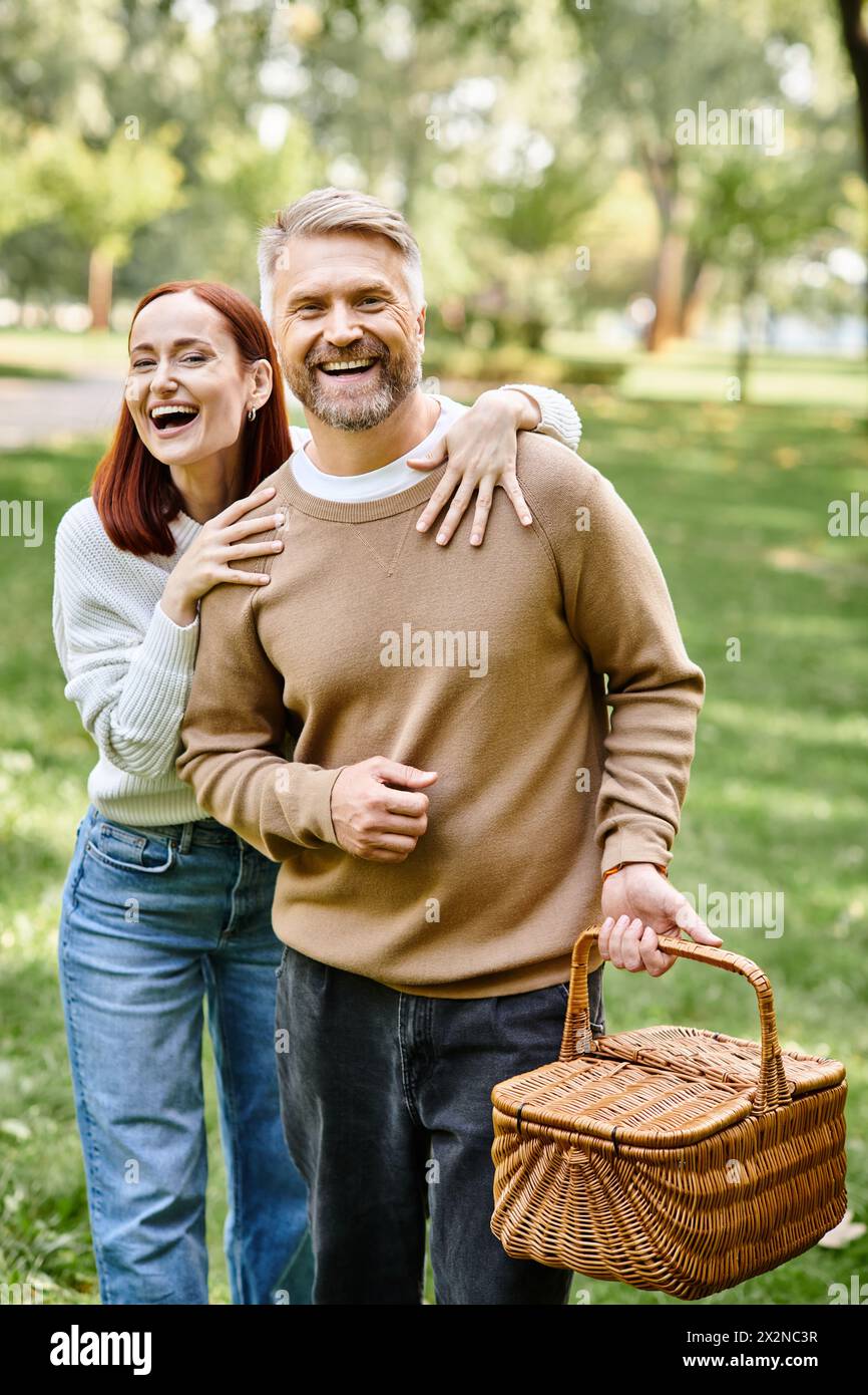 Ein Mann und eine Frau in lässiger Kleidung machen einen gemütlichen Spaziergang durch einen ruhigen Park. Stockfoto