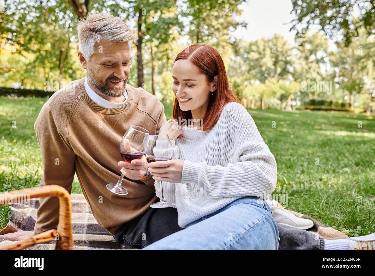 Ein Paar genießt Wein auf der Decke im Park. Stockfoto