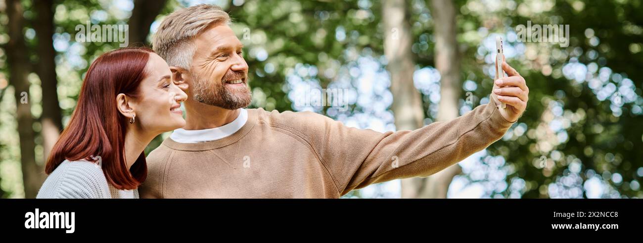 Ein Paar macht ein Selfie im Wald während eines gemütlichen Spaziergangs. Stockfoto